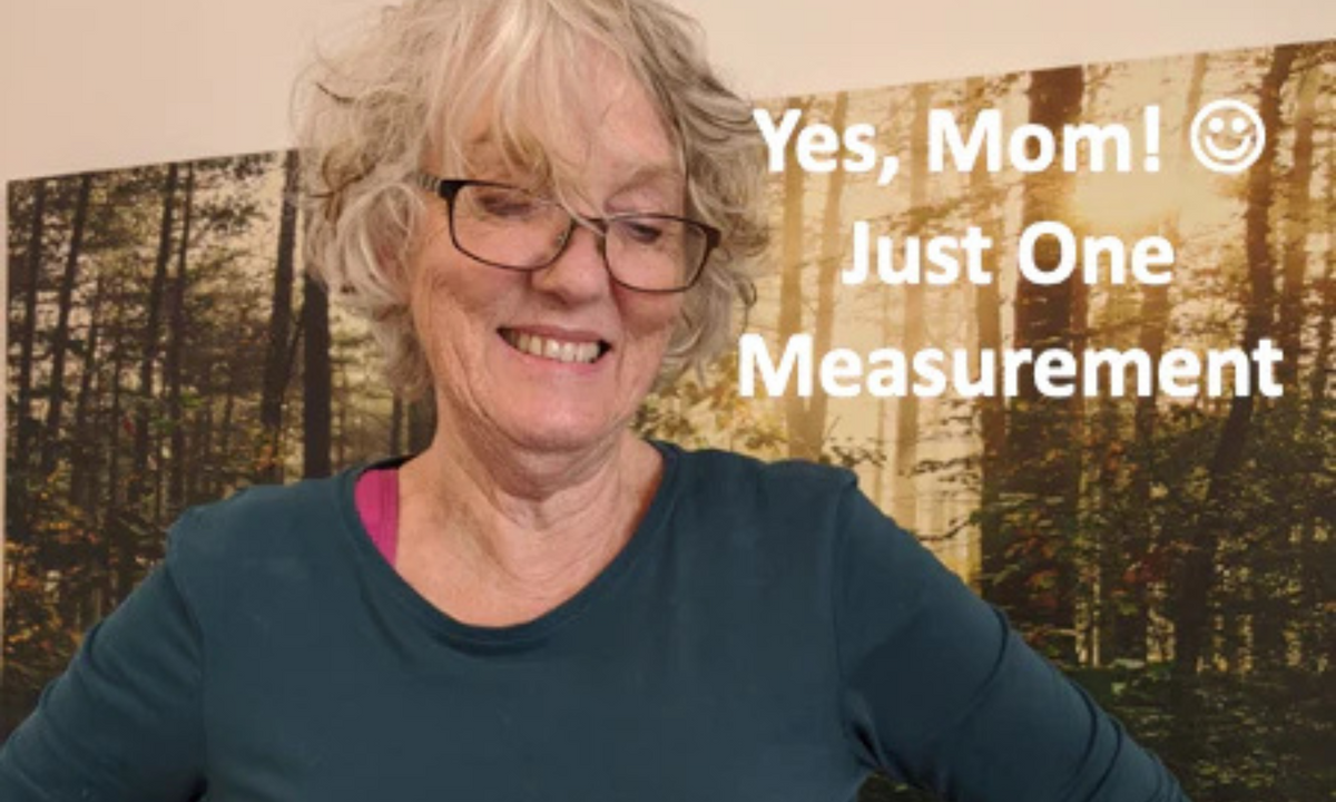 Yes, Mom! Just One Measurement: smiling woman with grey hair and glasses in a teal top before a forest mural