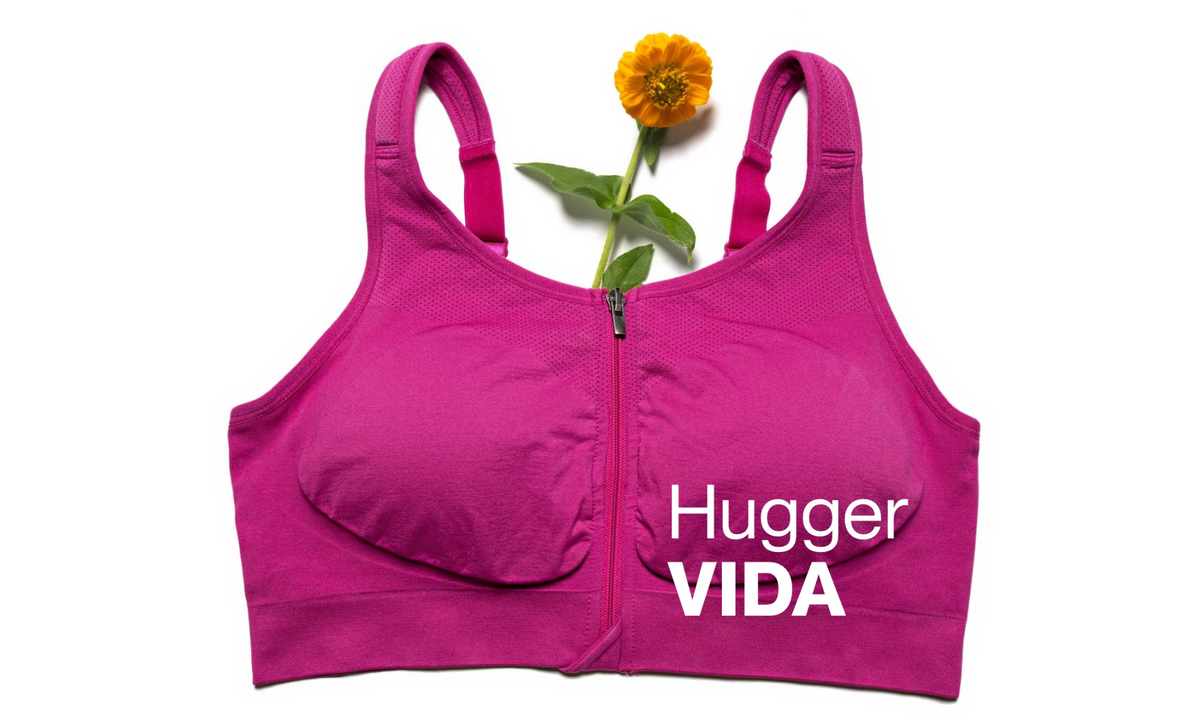 HuggerVIDA front-zip bra in Prairie Dawn pink laid flat with an orange flower and its name printed on it