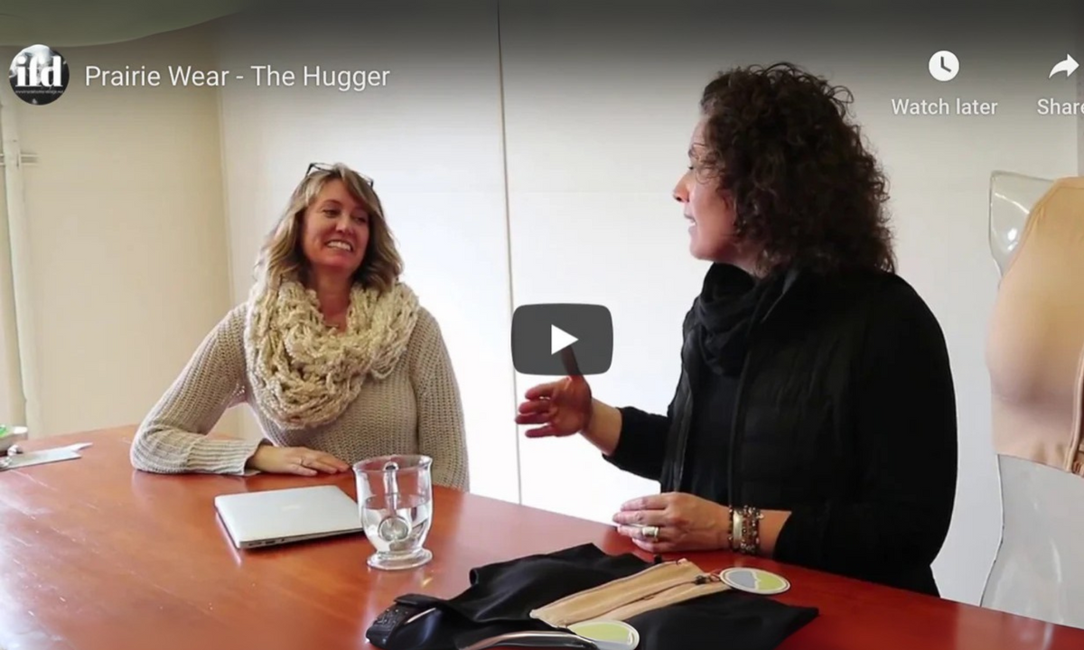 Inside Fashion Design video, Prairie Wear The Hugger: two women talk at a table beside bras and a laptop