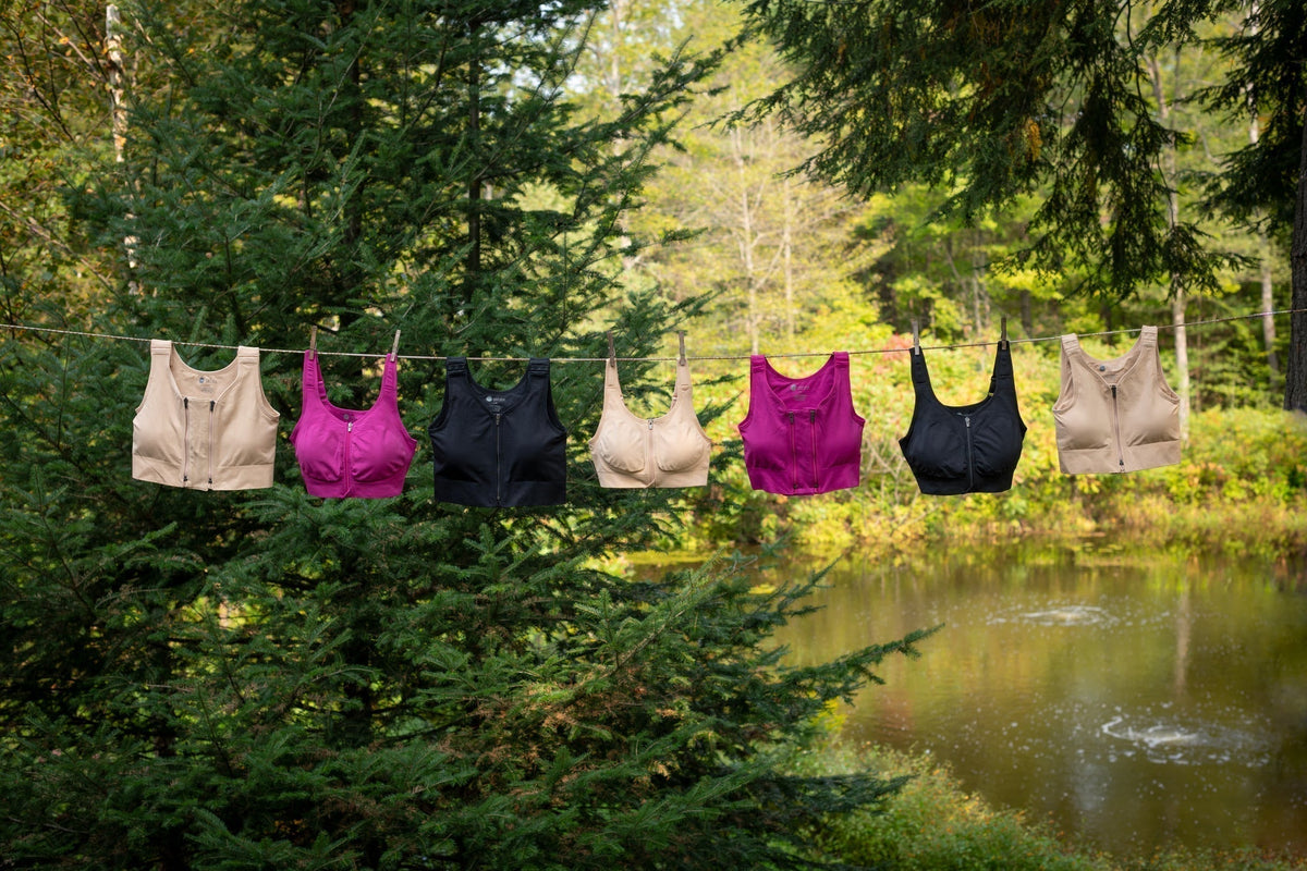 Several Prairie Wear Hugger compression bras hanging on a clothesline outdoors to dry