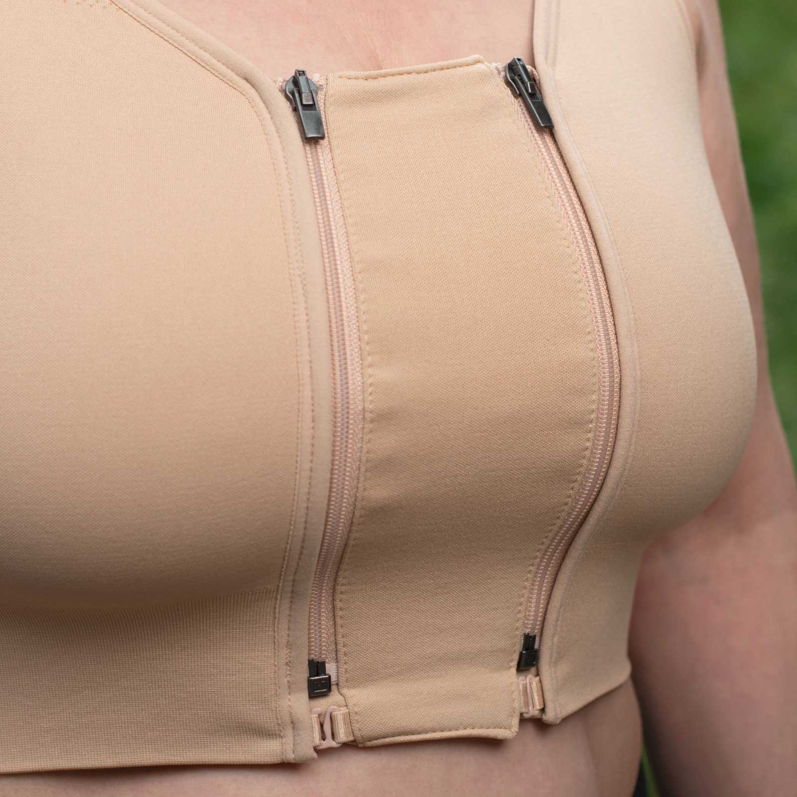 Zip-in Extender shown close-up zipped into the HuggerPRIMA in Wheat Beige. Made to vary the compression & breathability of the HuggerPRIMA for women in the process of breast surgery or with lymphedema who may have variable cup sizes and want to adjust the fit; women who are post-surgical and need compression 24/7 but would like a bit more space for sleeping or warmer weather; anyone who wants to adjust the size and fit of their HuggerPRIMA without buying an extra bra.